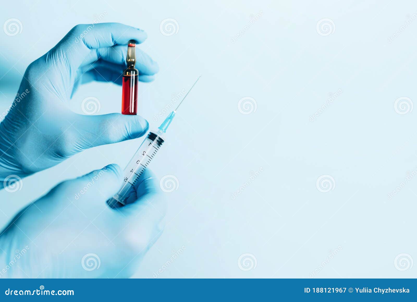 medicine, injections and vaccination concept. hands in medical gloves holding syringe and ampoule on blue background. copy space.
