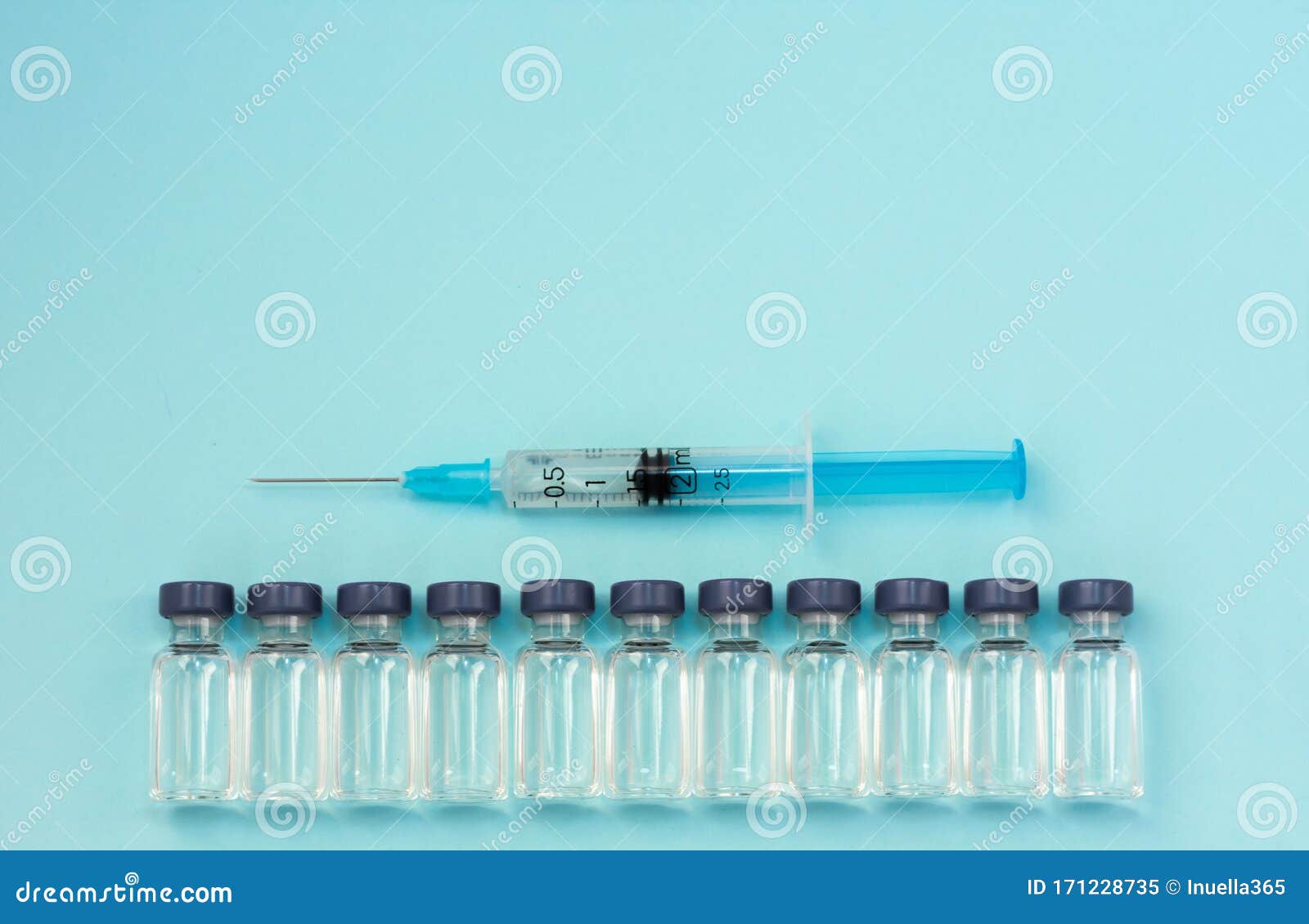 Medicine in Vials, Ready for Vaccine Injection and Syringe on Blue