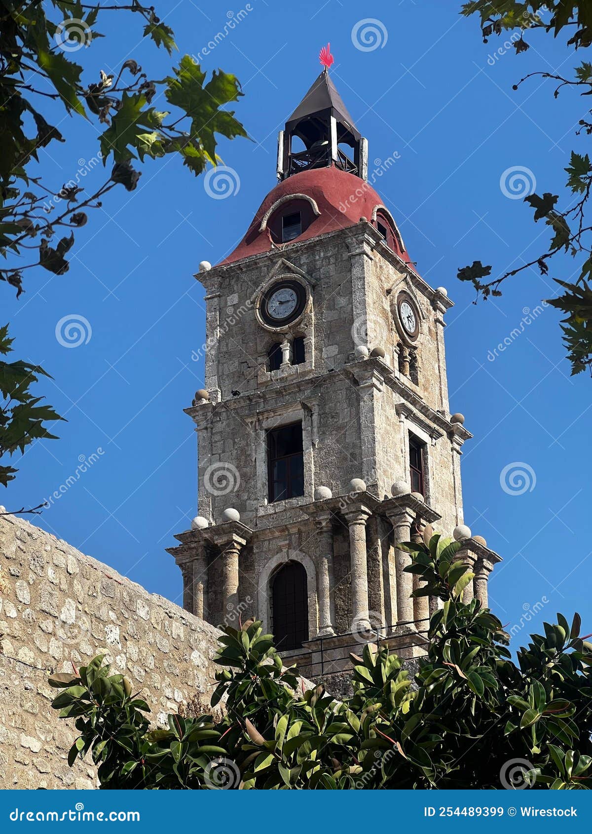 medieval clock tower surrounded by trees in rhodes town