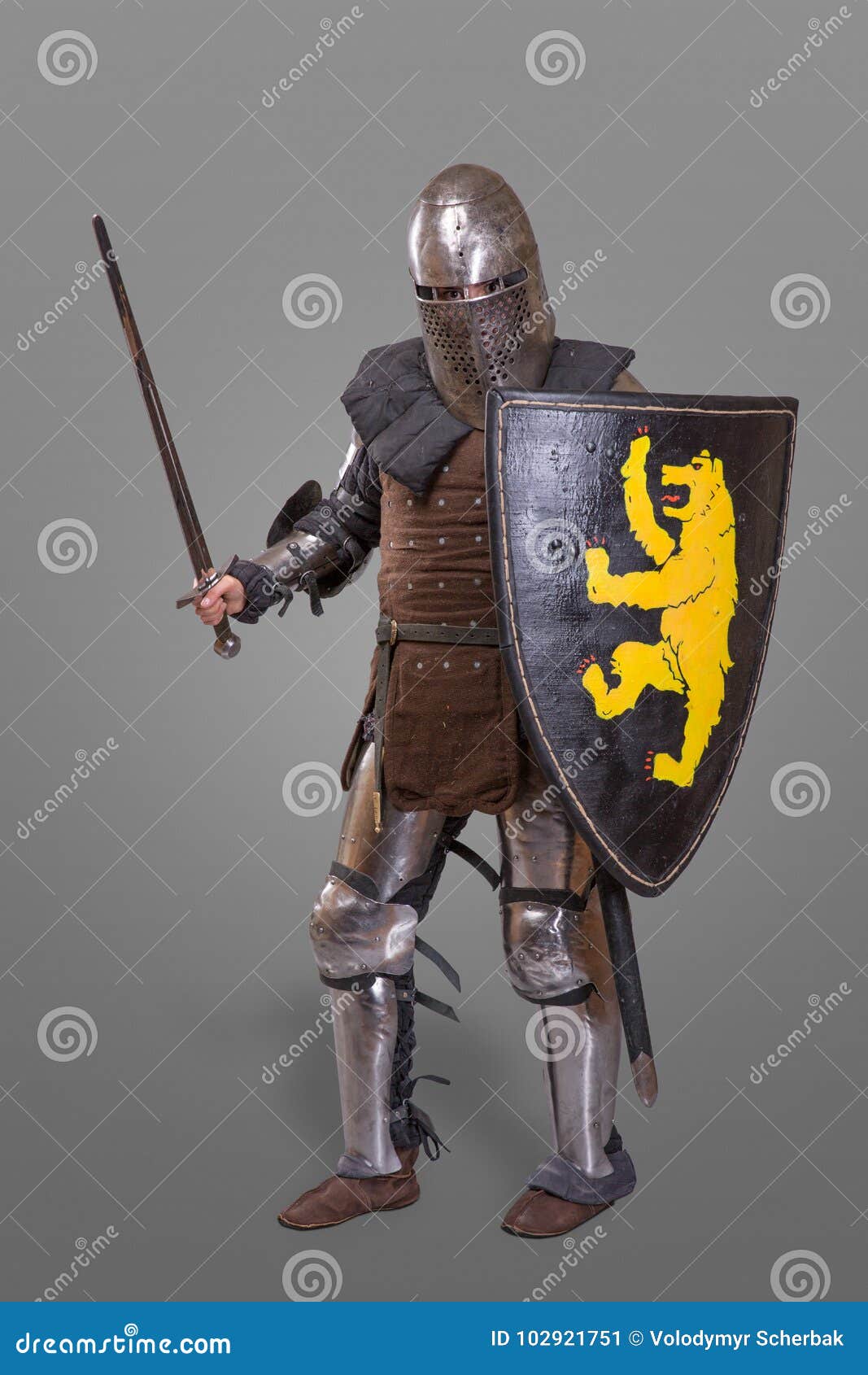 Medieval Knight With Sword, Shield, Helmet Against Grey Background