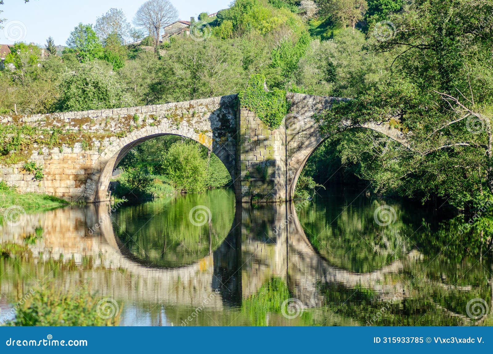 medieval stone bridge over the arnoia river in the beautiful village of allariz, galicia