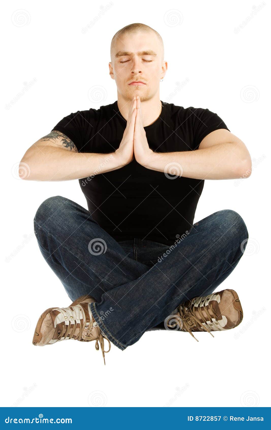 Meditatie. De geïsoleerdeu mens mediteerde in zwart overhemd en blauwe jenas zittend op de grond met gekruiste benen op witte achtergrond