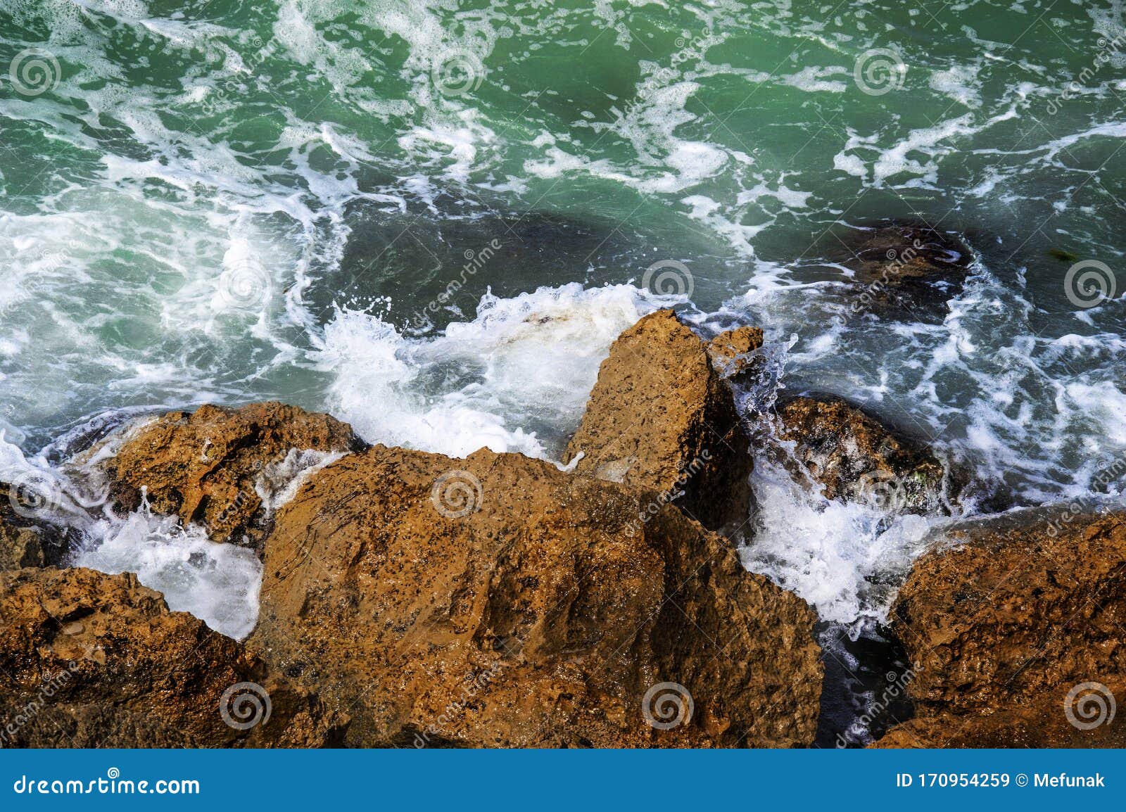 mediterranian sea. green water and beach rocks