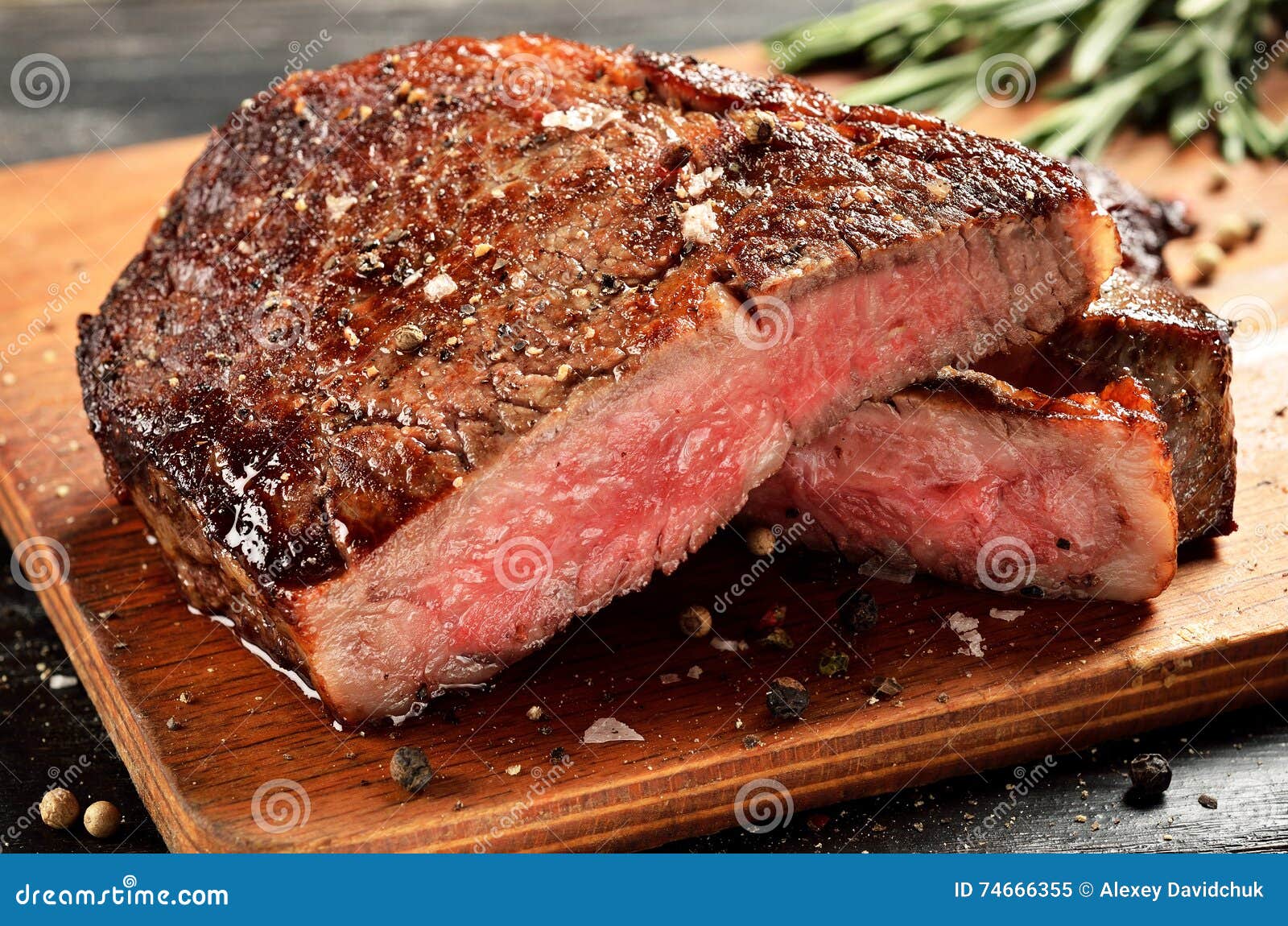 medium rare ribeye steak on wooden board, selected focus