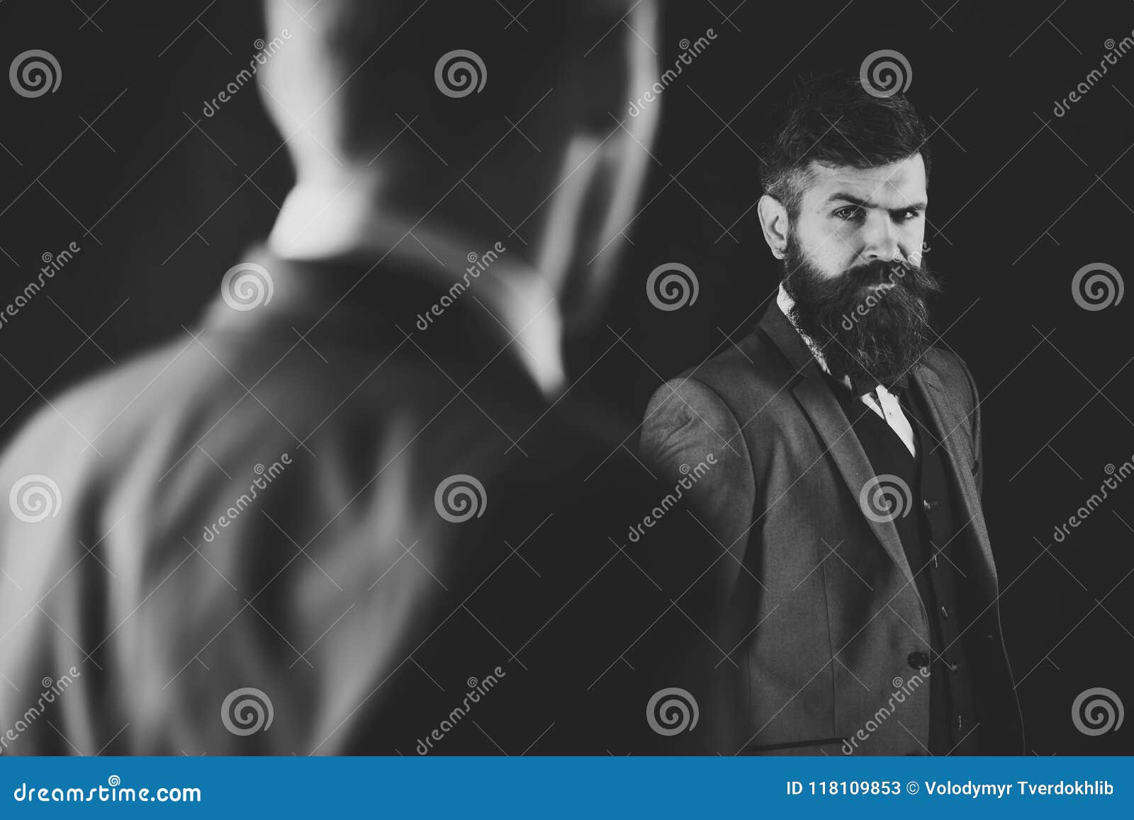 meeting of reputable businessmen, black background. man with beard on suspicious face, and shoulders of partner
