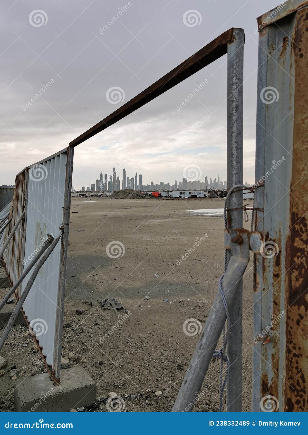 a megapolis outskirts revealling a jagged line of skyscrappers in the open gate of a construction zone