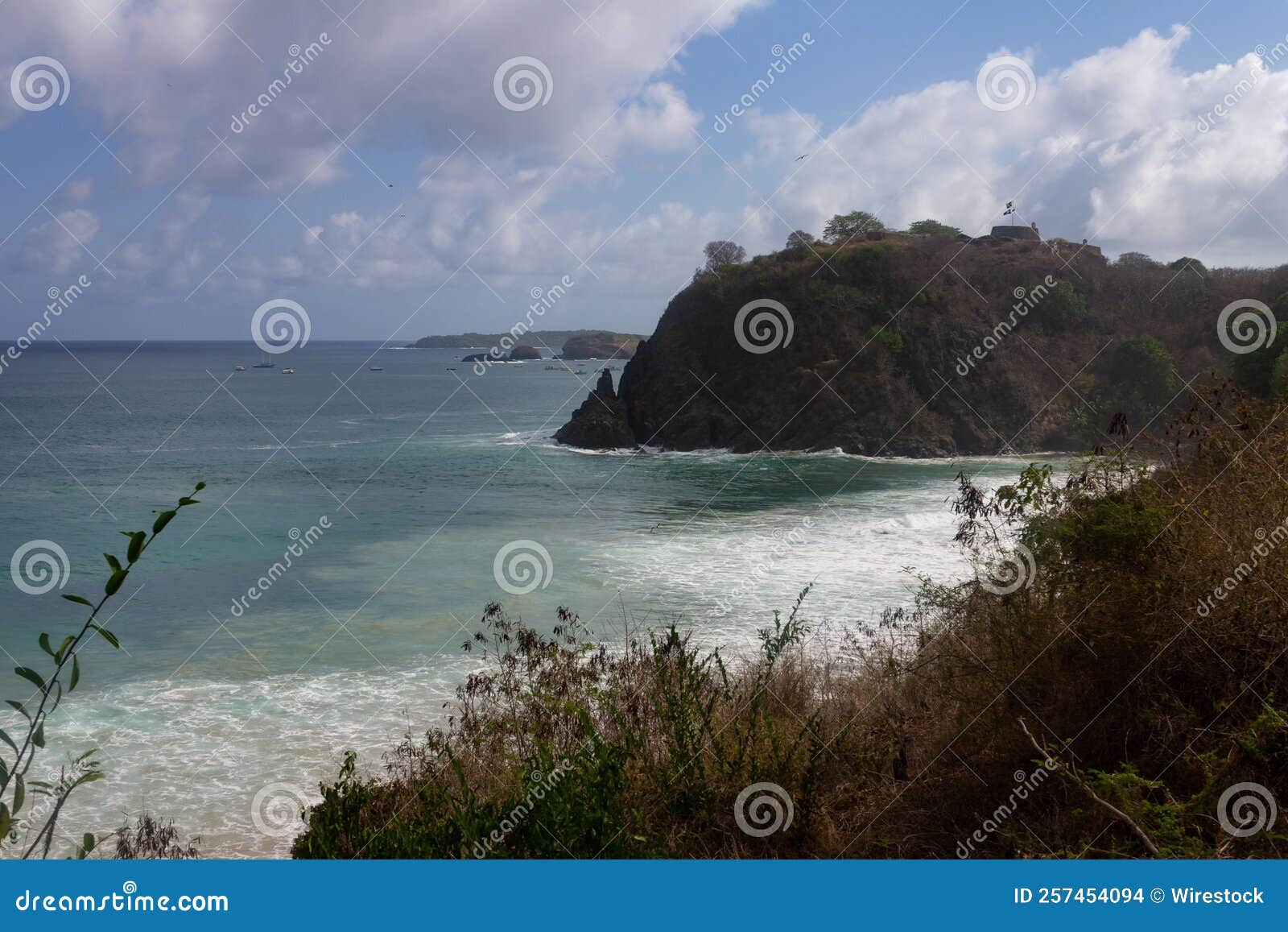 meio beach in brazil with a rocky shore on a bright sunny day