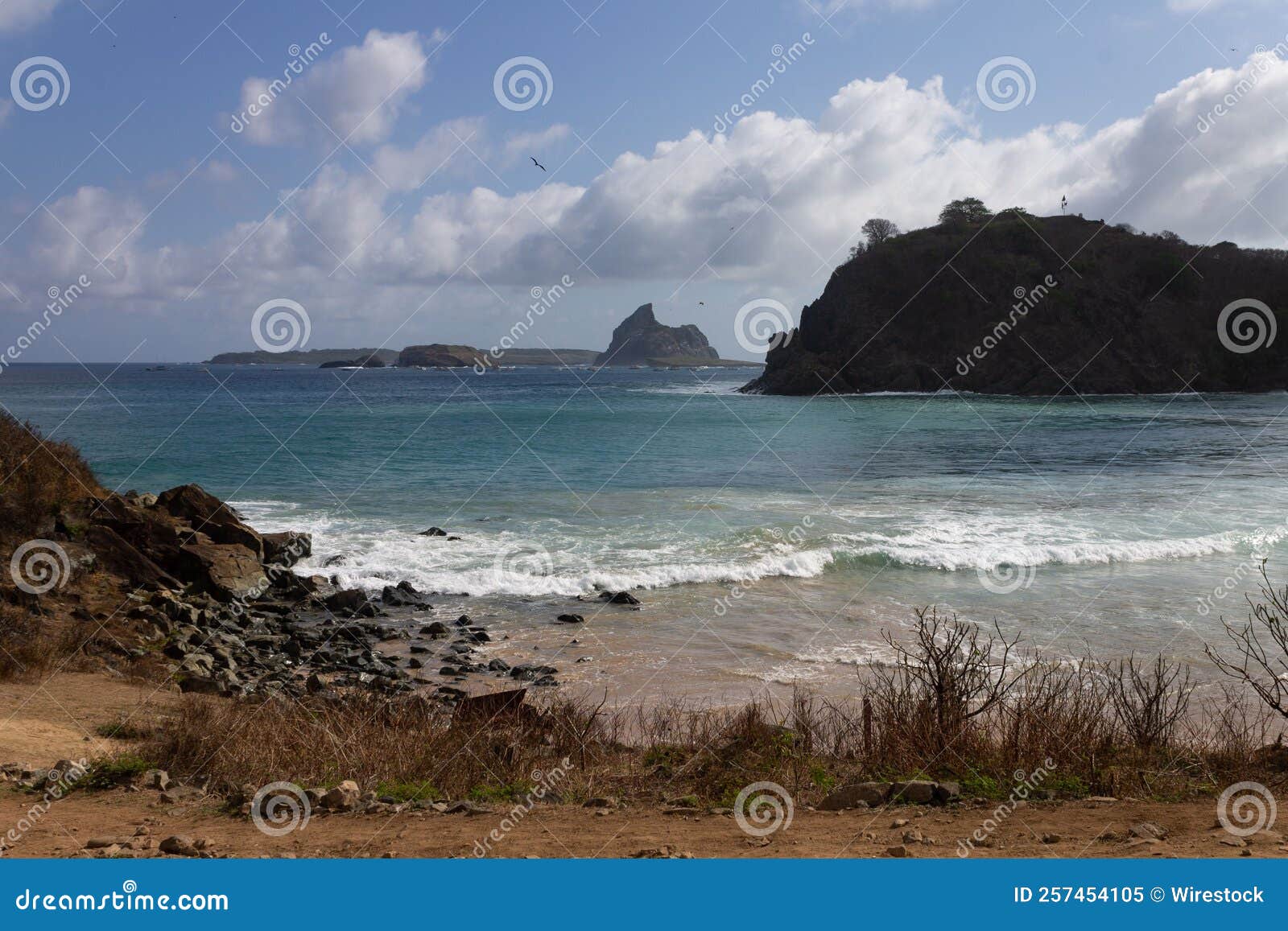 meio beach in brazil with a rocky shore on a bright sunny day