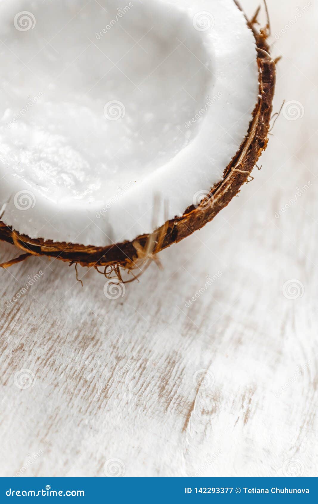 Meio coco em um fundo de madeira branco claro, close up Vista superior