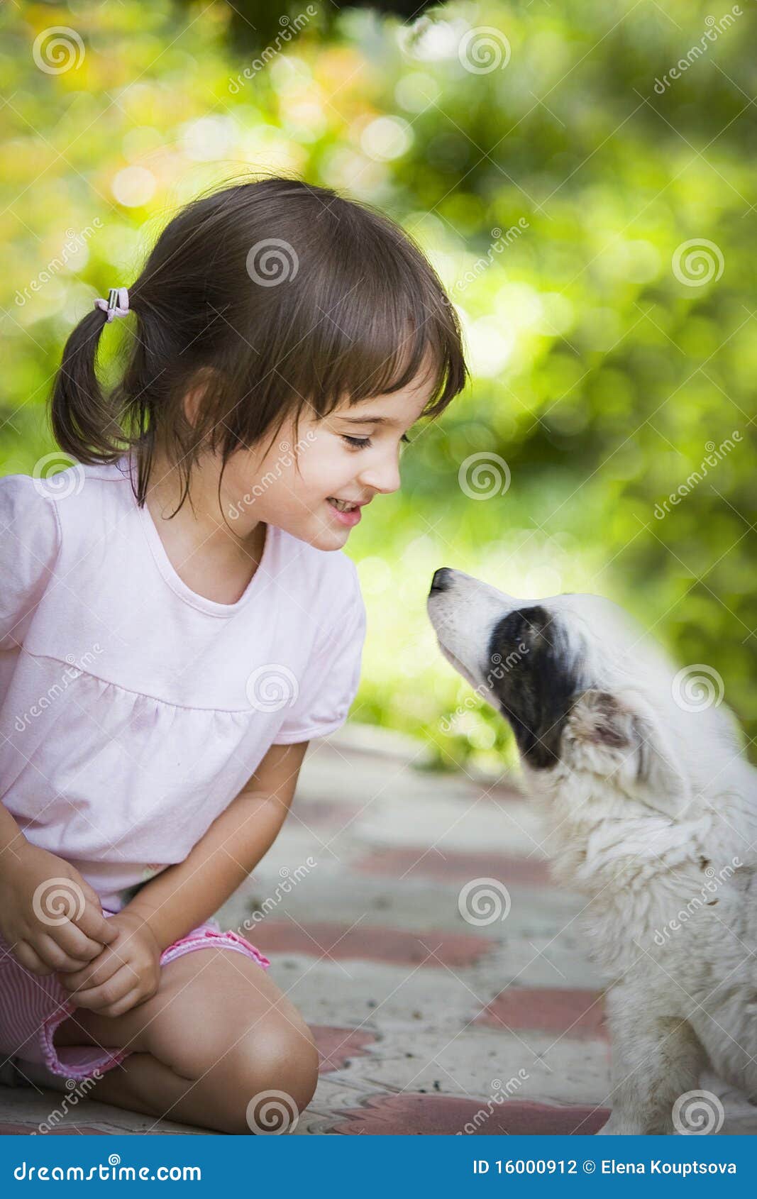 Meisje en puppy. Het spelen van het meisje met puppy