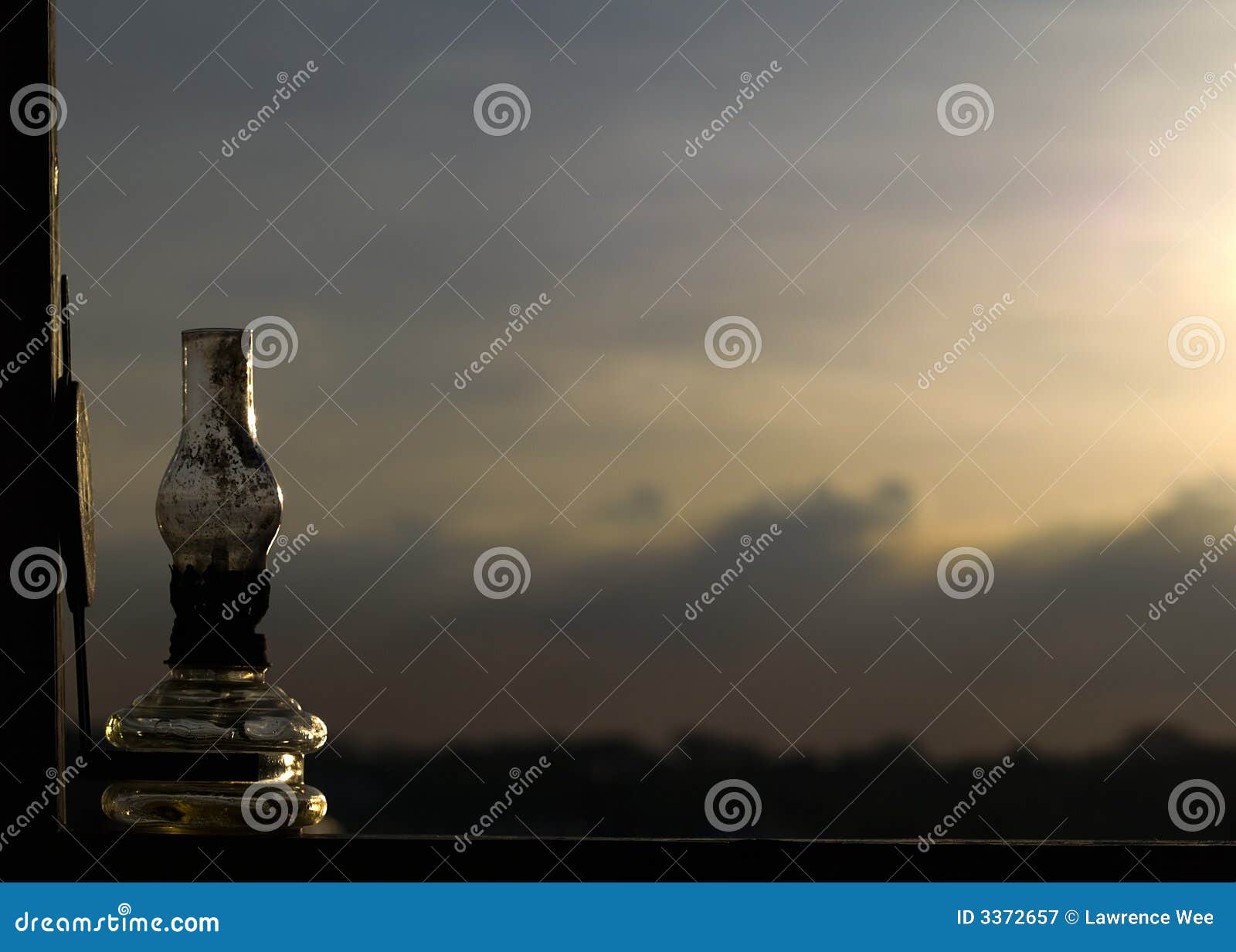 Melancholie. Roetige roestige de olielamp van Unlit op venstervensterbank die de laatste stralen die van de het plaatsen zon vangt, tot een melancholische longing anticpation leiden.