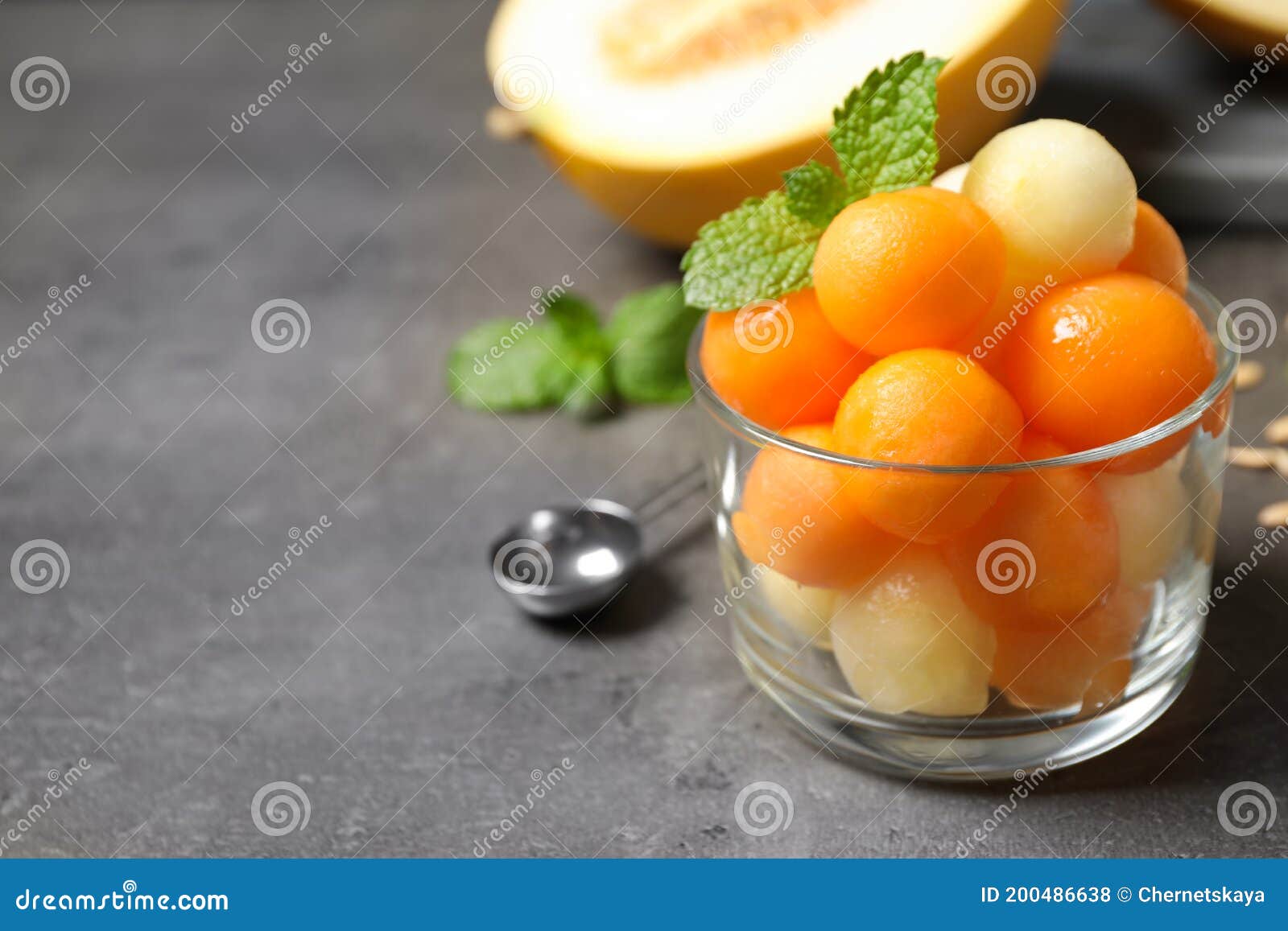 Melon Balls and Mint in Glass on Grey Table, Closeup. Space for Text