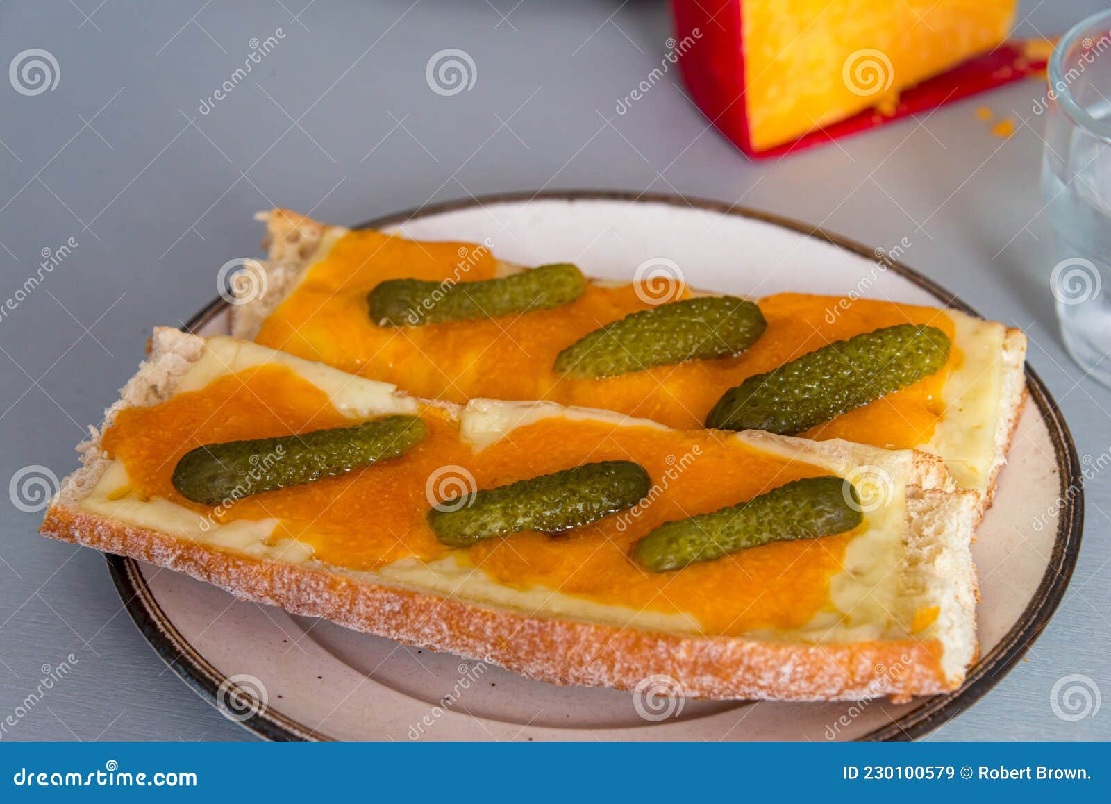 Melted Cheddar Cheese on French Bread with Gerkin Topping Stock Image