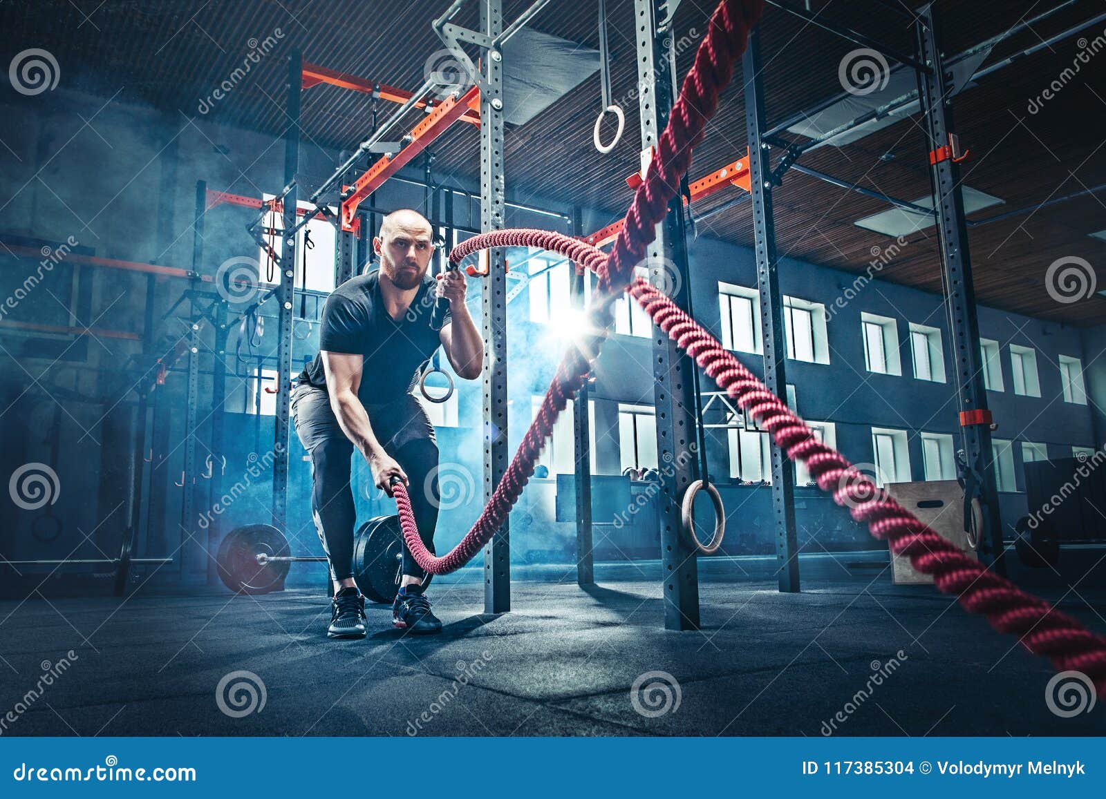 men with battle rope battle ropes exercise in the fitness gym.