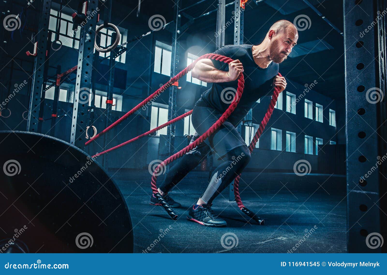 Men with Battle Rope Battle Ropes Exercise in the Fitness Gym