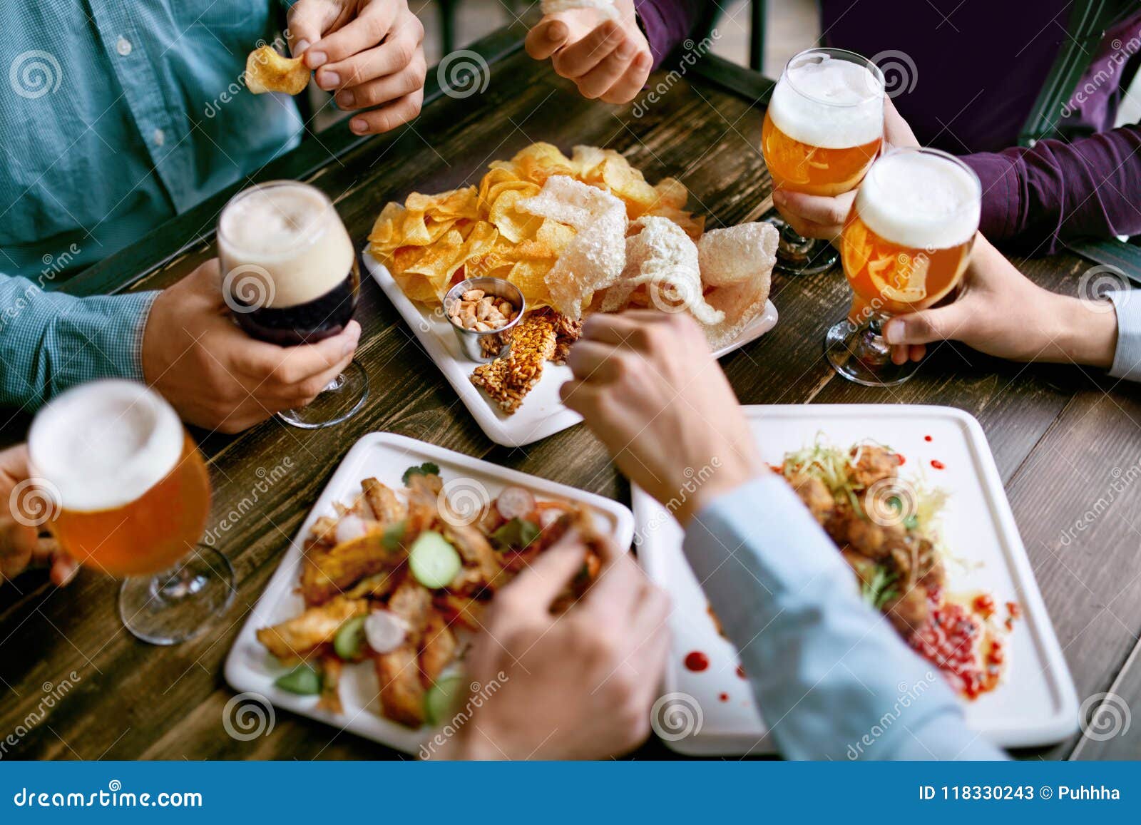 men drinking beer and eating food closeup