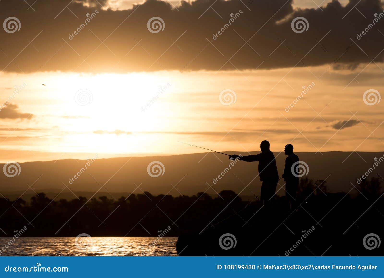 men fishing at the lake at sunset