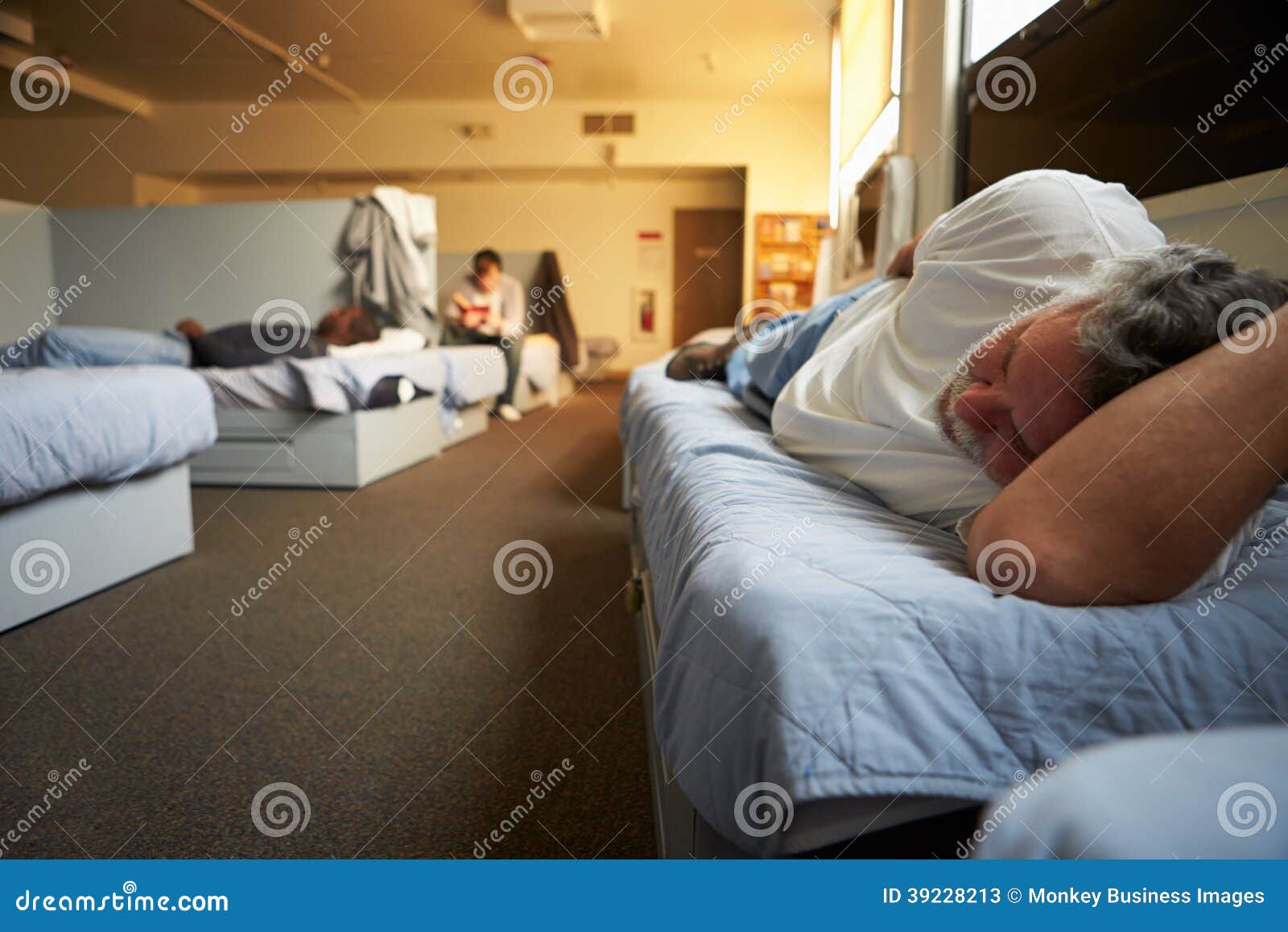 men lying on beds in homeless shelter