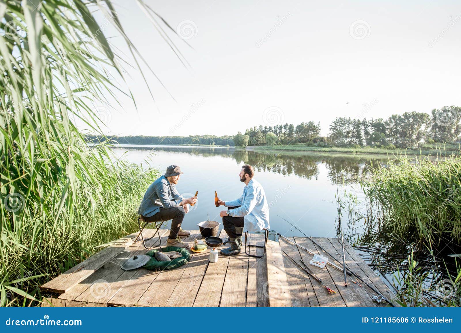 Men Relaxing with Beer while Fishing on the Lake Stock Photo
