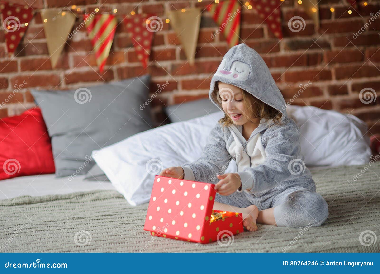 A Menina Bonito 8-9 Anos, Senta-se Em Uma Cama Com O Presente Do Natal Nas Mãos Foto de Stock - Imagem de intriga, festivo: 80264246 A Menina Bonito 8-9 Anos, Senta-se Em Uma Cama Com O Presente Do Natal Nas Mãos Foto de Stock - Imagem de intriga, festivo: 80264246