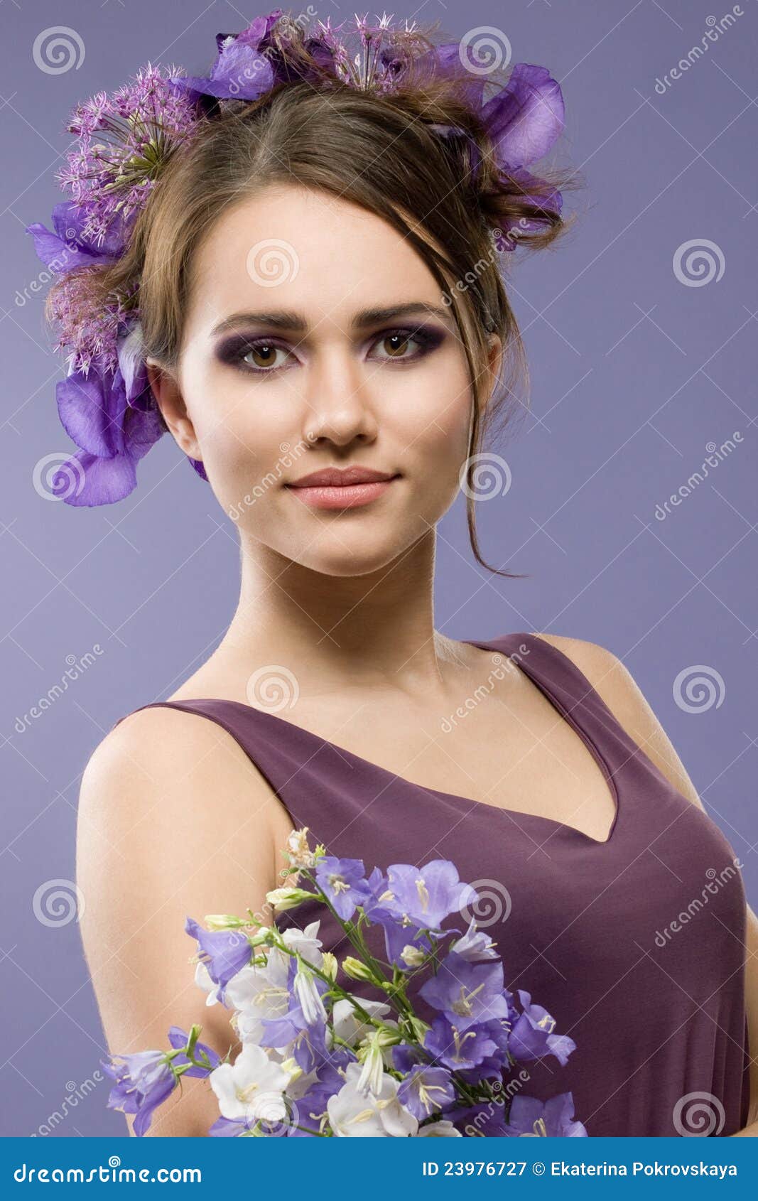 Menina com flores. Retrato do estúdio de uma menina bonita com flores violetas