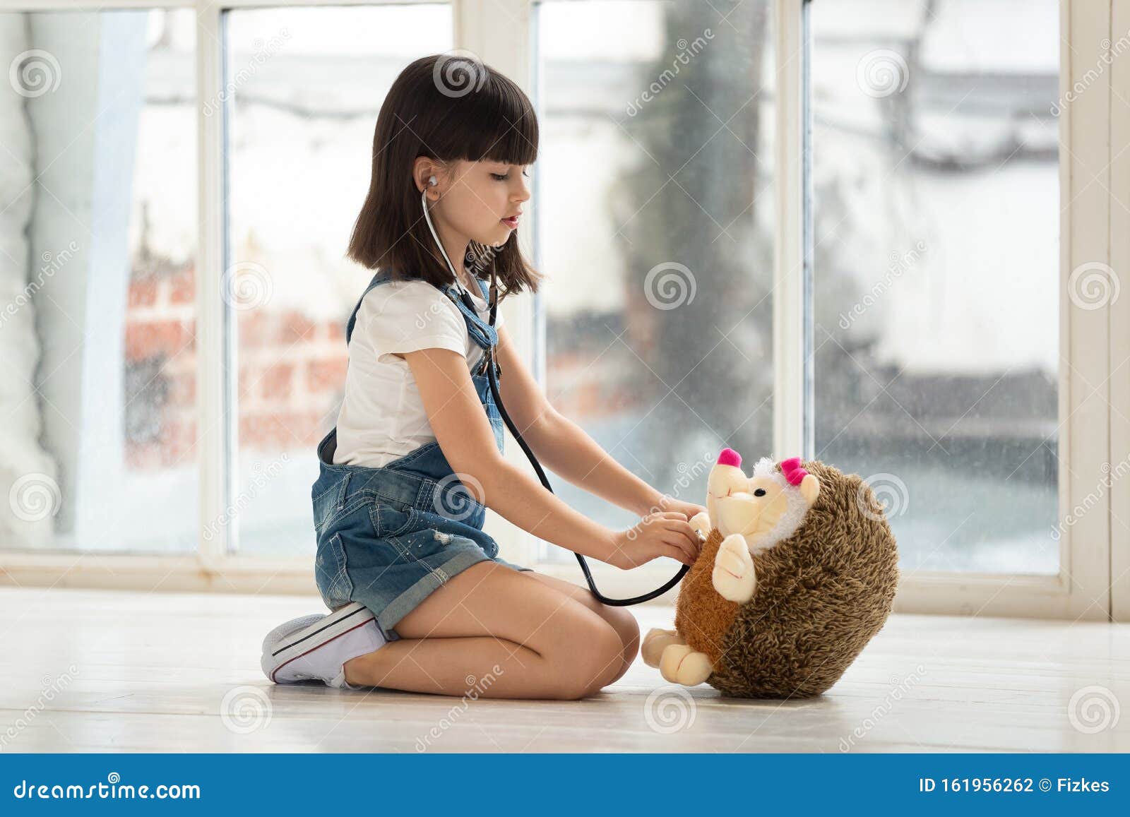 menina dos desenhos animados brincando de médico com brinquedo de