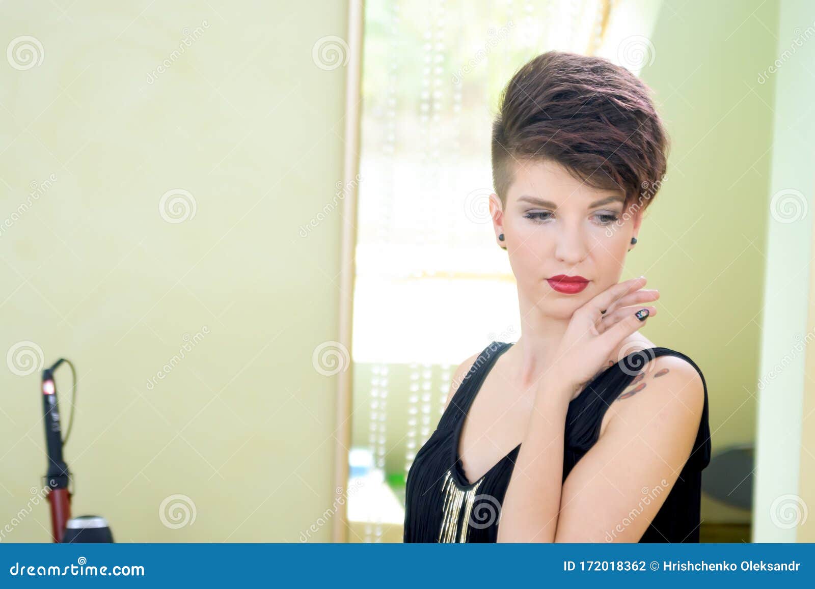 Uma mulher com cabelo curto e um vestido preto com um logo preto