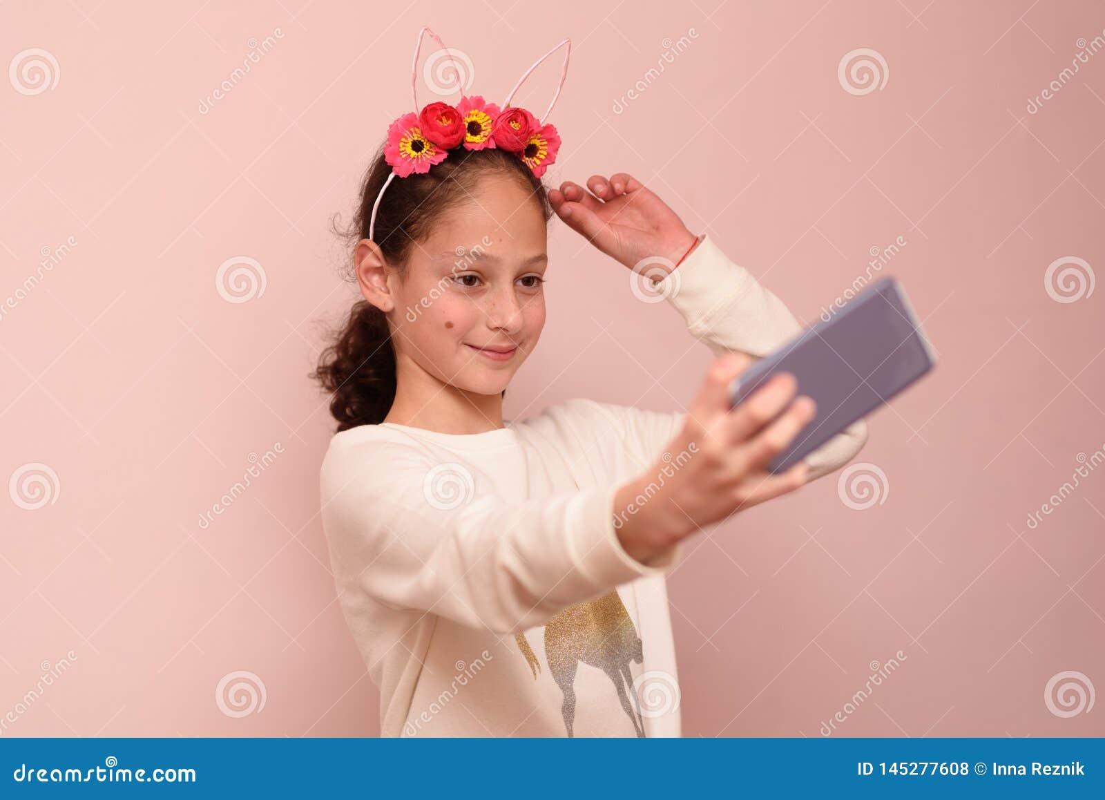 Menina Do Adolescente Com O Diadema Das Flores Que Tomam O Selfie Com Seu  Telefone Celular No Fundo Cor-de-rosa Foto de Stock - Imagem de flores,  telefone: 145277608