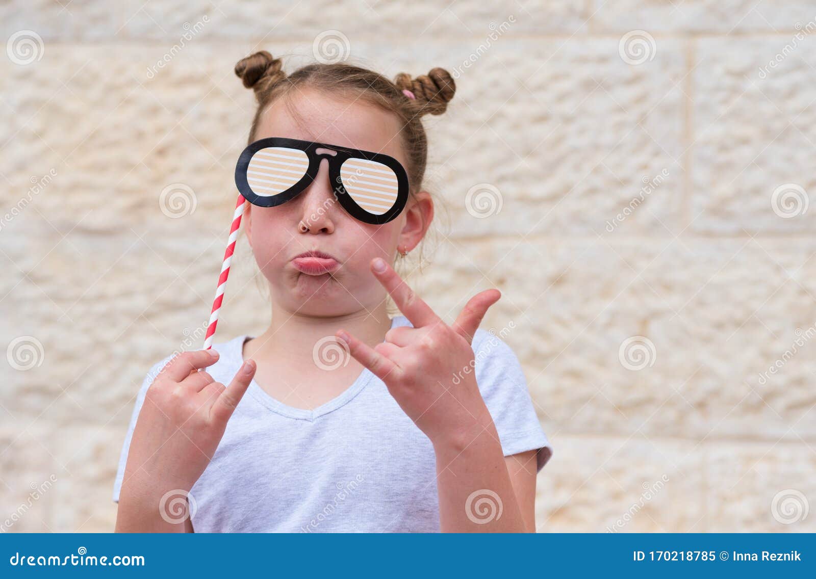 Menina segurando óculos de papel engraçados se divertindo jogando jogo  usando acessório de máscaras