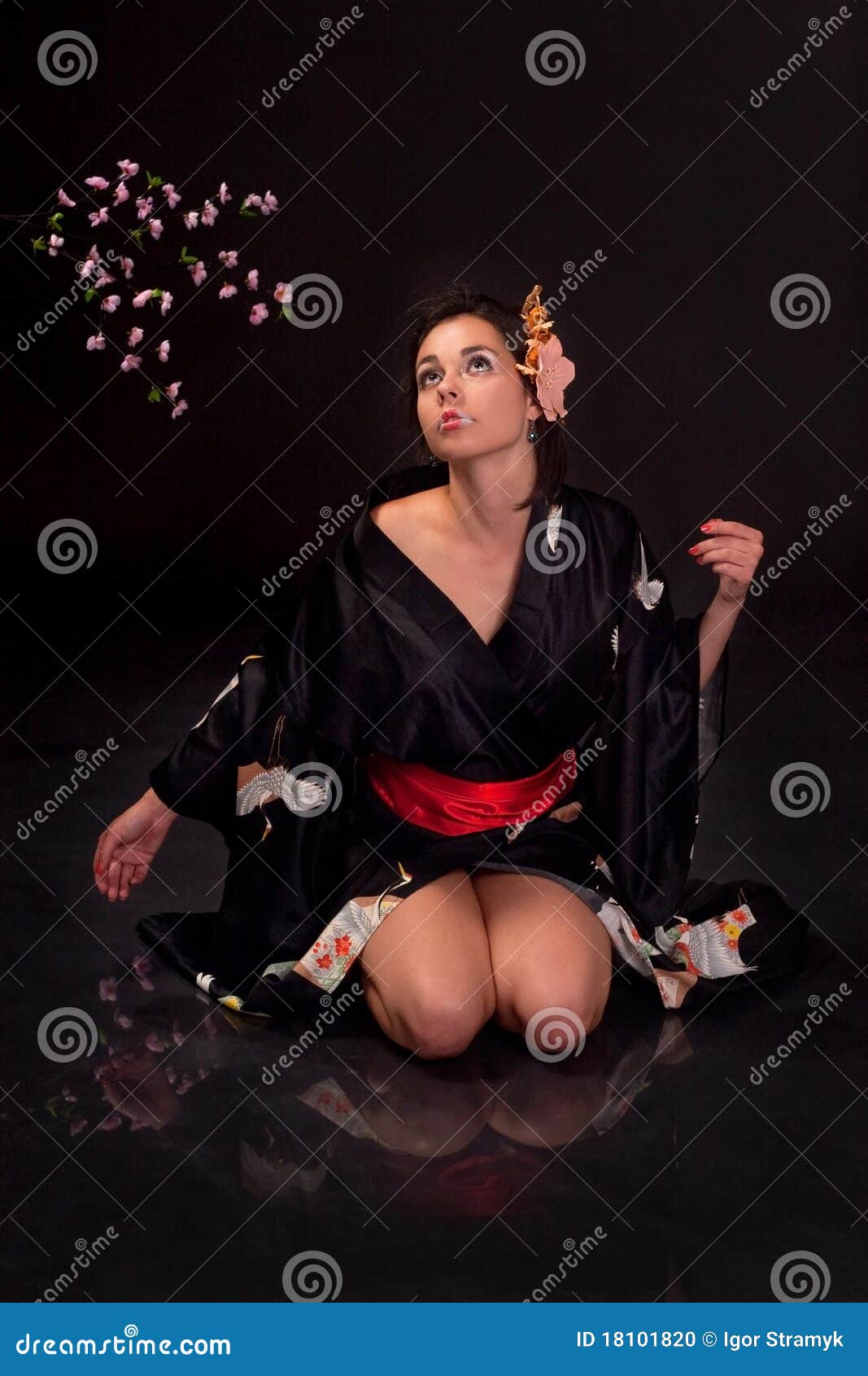 Menina japonesa na roupa tradicional que levanta à câmera