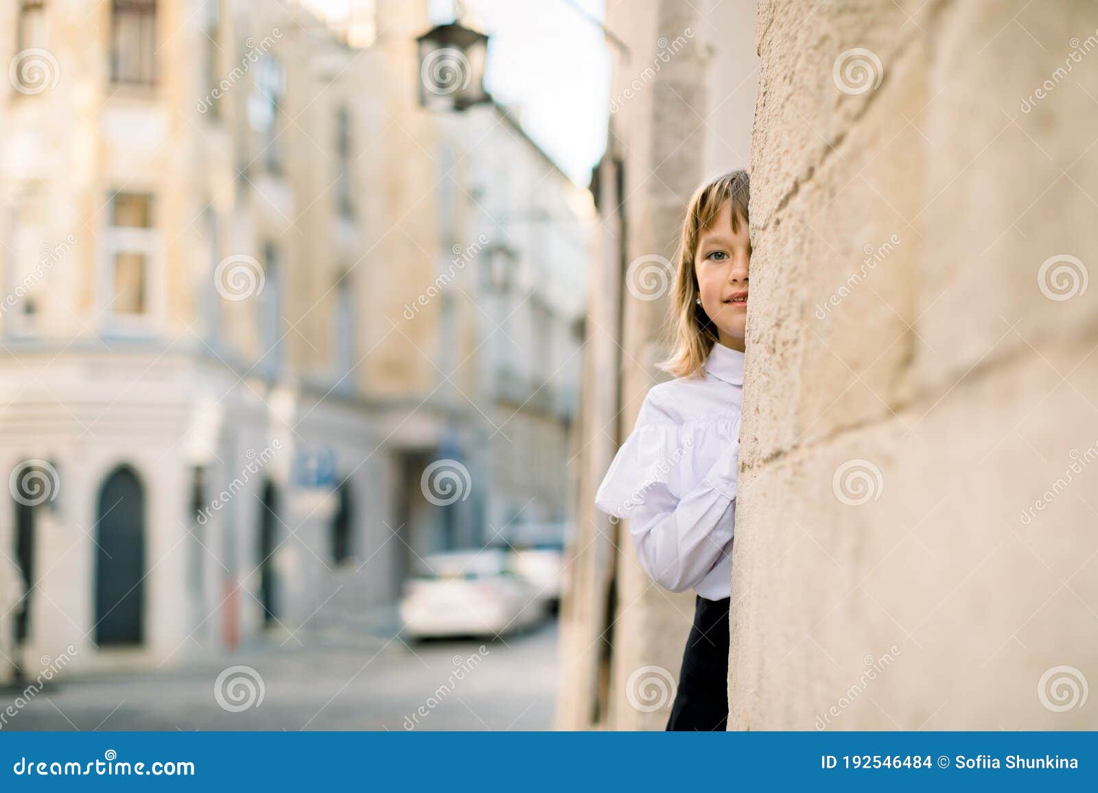 Duas lindas meninas sentadas em frente a um velho muro de pedra