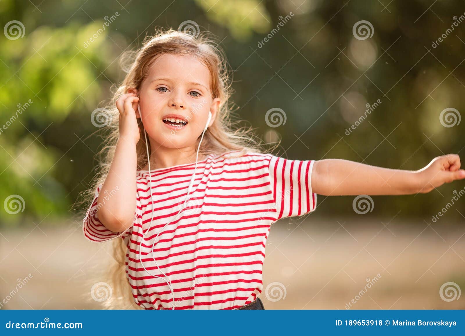 Menina ouvindo música em fones de ouvido na parede rosa. garota