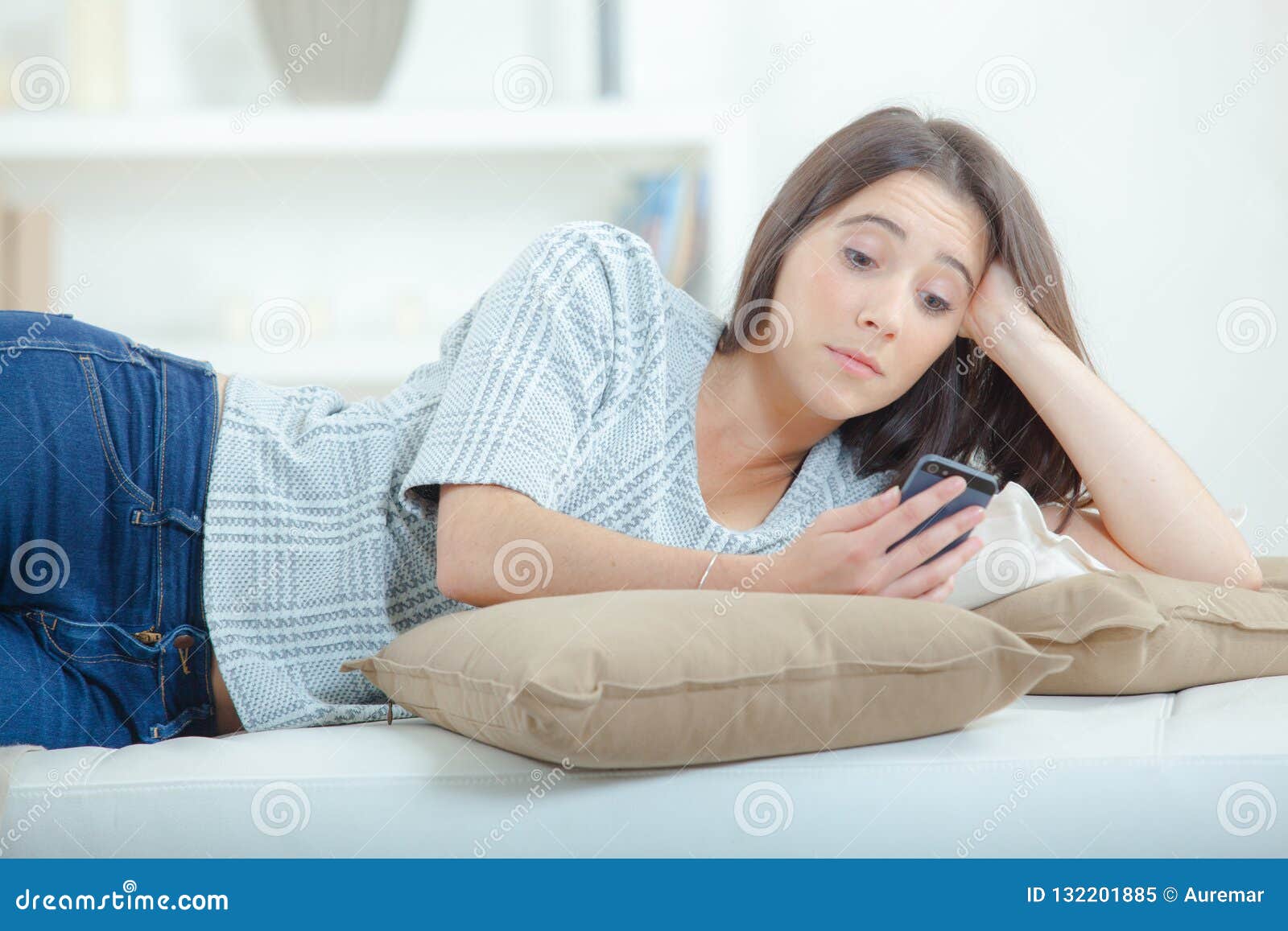 Menina que lounging com telefone celular. Menina que lounging com aplicações do telefone celular