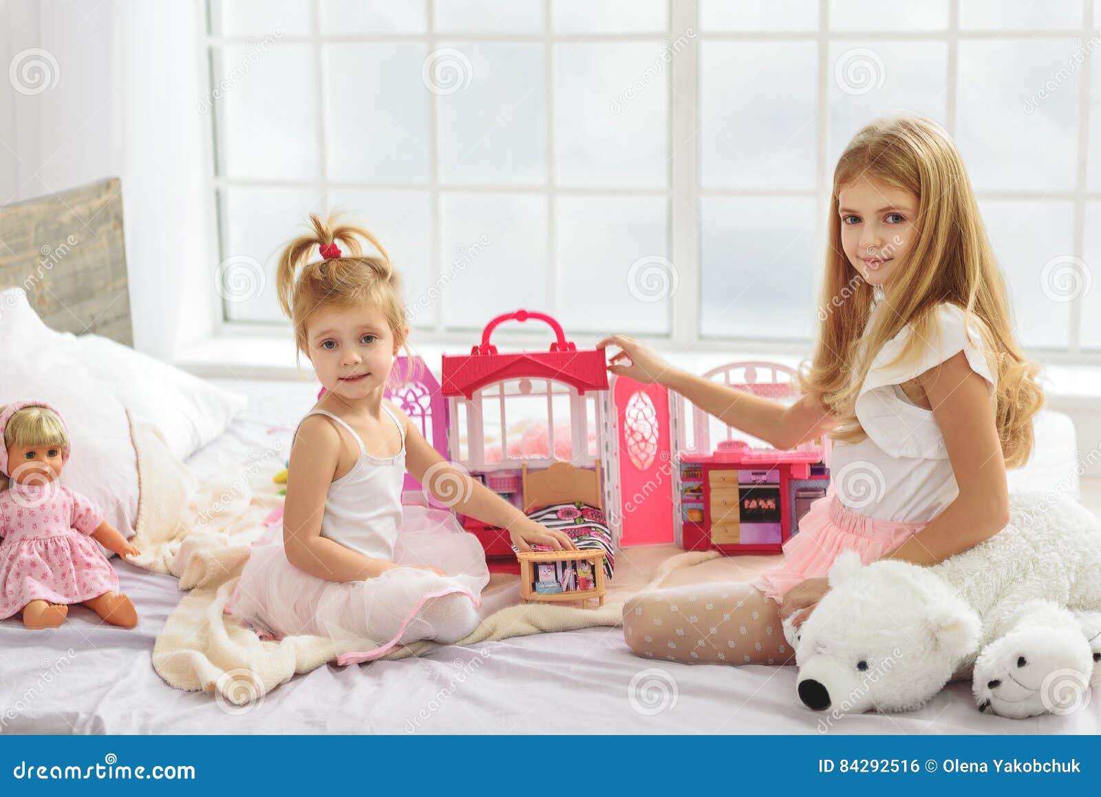 Meninas Bonitas Que Apreciam O Jogo Com Bonecas Foto de Stock - Imagem de  cama, colorido: 84292516