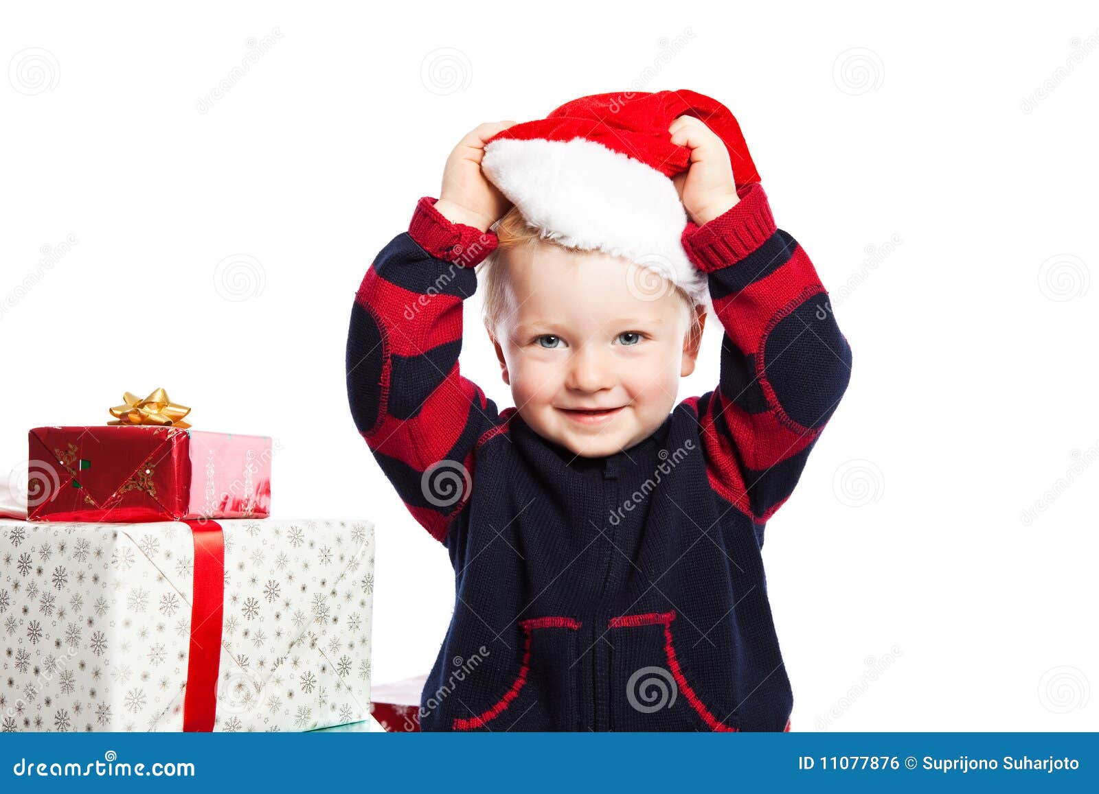 Menino com presente do Natal. Um menino caucasiano que desgasta um chapéu de Santa com muito presente do Natal