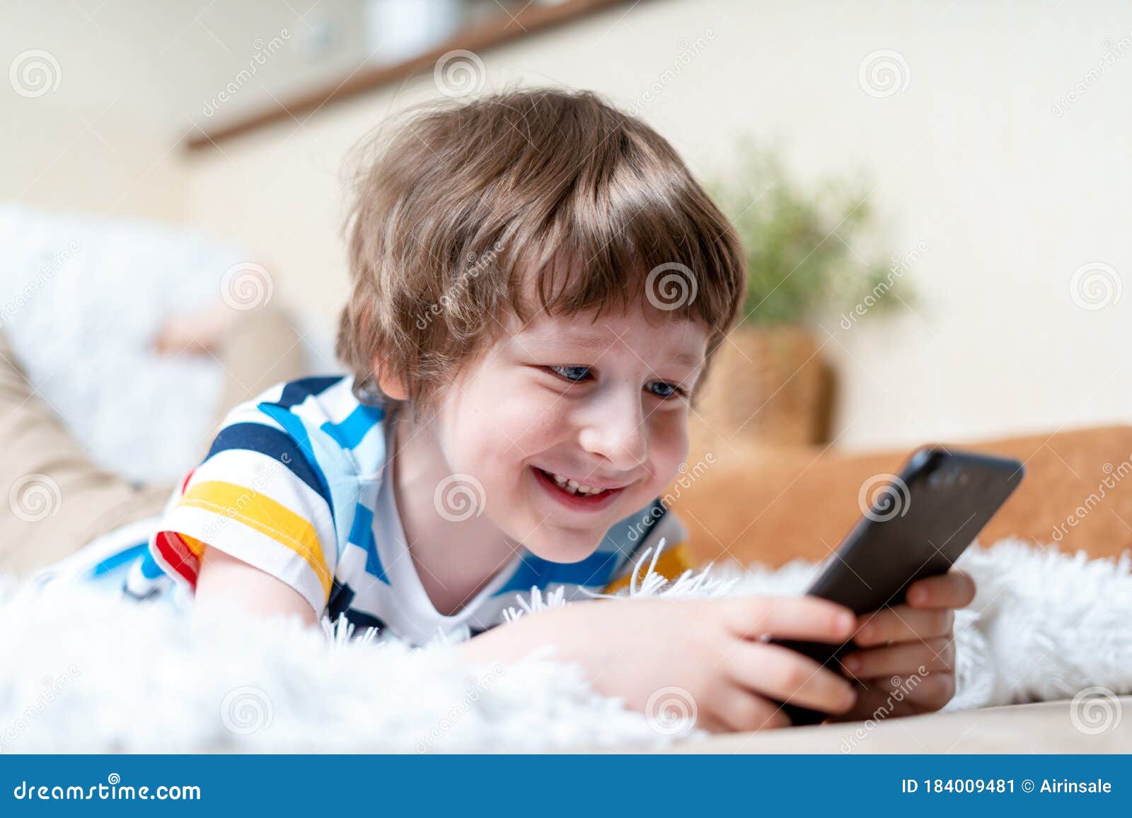 retrato menino jogando no celular enquanto espera por comida, garoto  sentado na cafeteria enviando texto para amigos, criança jogando jogo online  no celular. crianças com conceito de tecnologia 11248716 Foto de stock