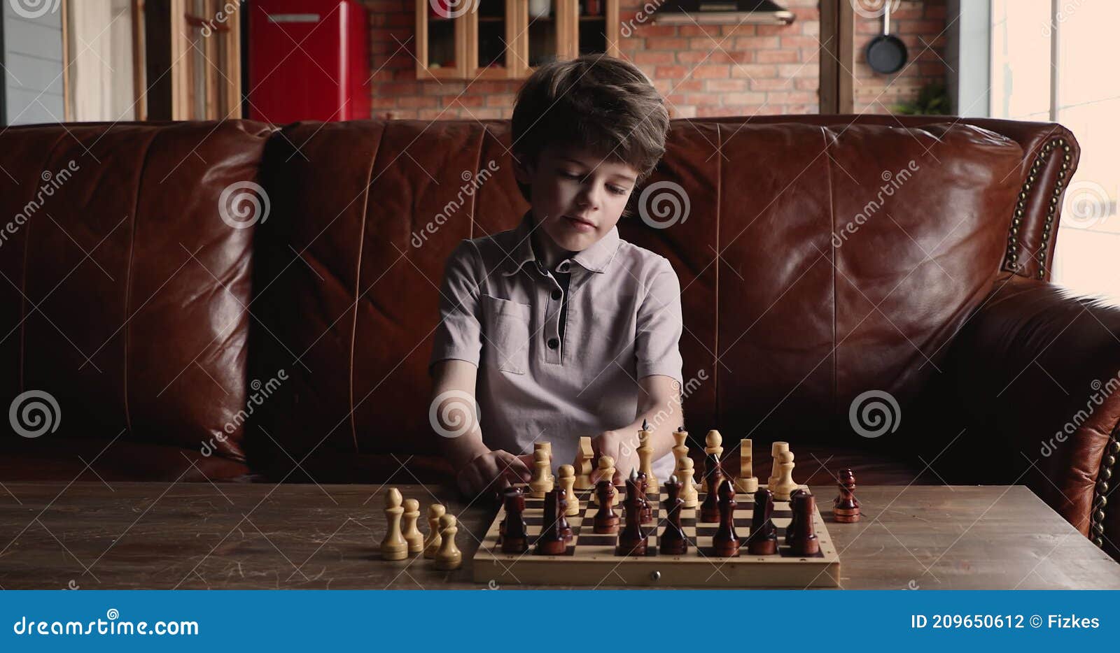 Menino fofo de 5 anos jogando xadrez sozinho em seu quarto em casa