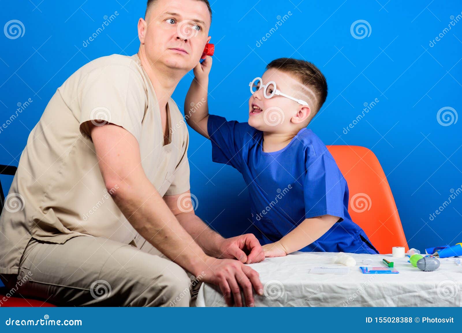 Small boy with dad in hospital. happy child with father with stethoscope. family doctor. medicine and health. father and son in medical uniform. small boy play with father. small boy doctor.