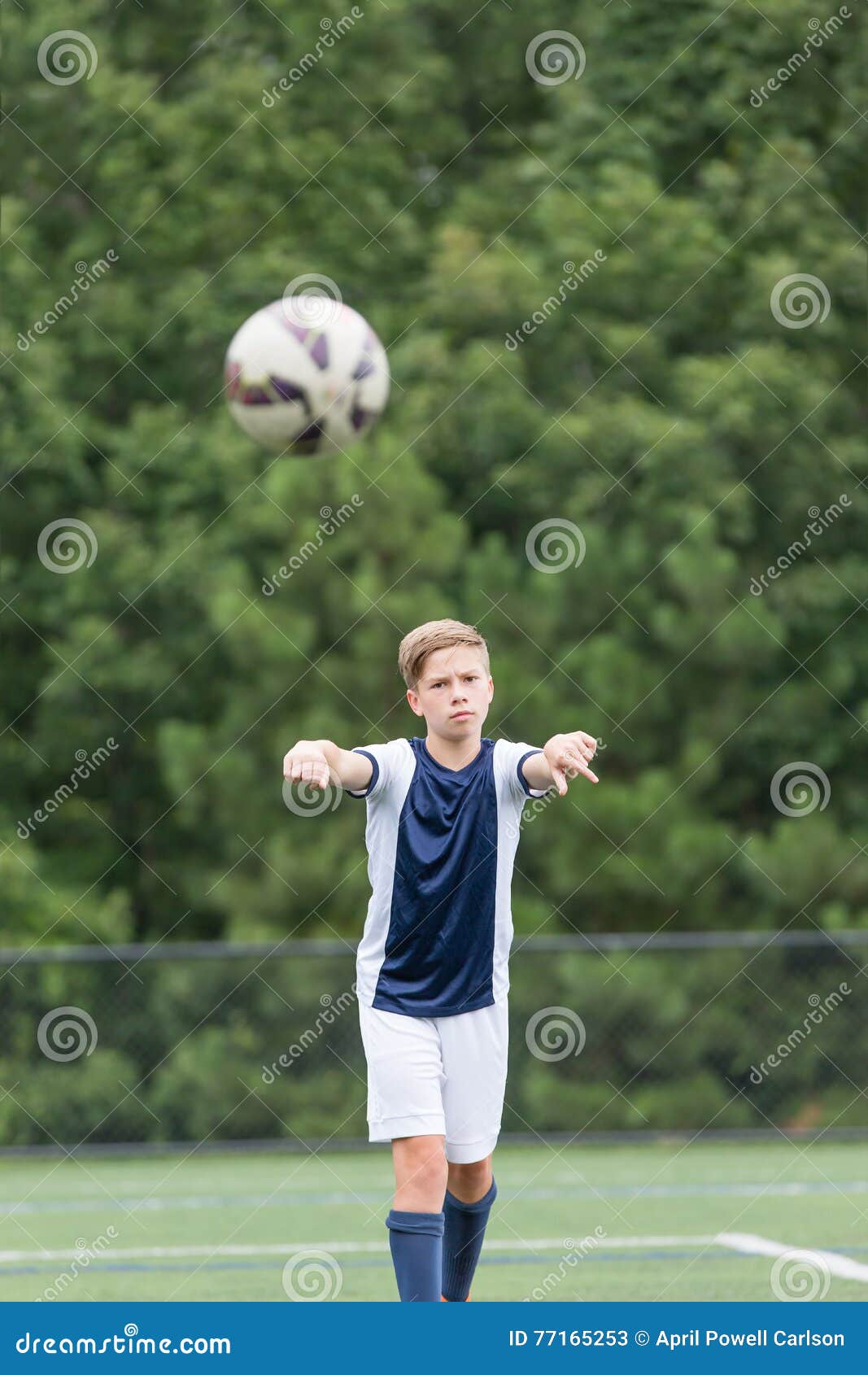 Menino Que Joga O Futebol - Tomando Um Lance Dentro Imagem de