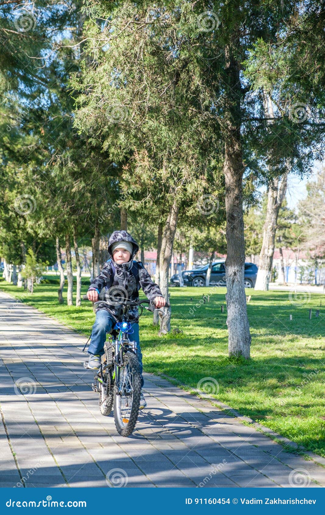 Menino que monta uma bicicleta no parque