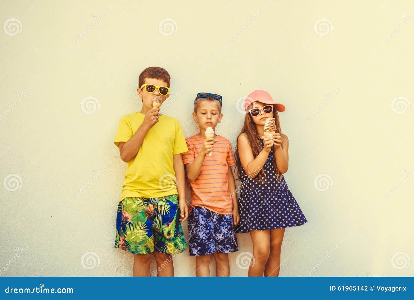 Meninos e menina das crianças que comem o gelado. Crianças que comem o gelato e o gelado macio do saque Os meninos e a menina nos óculos de sol que apreciam férias de verão vacation Filtro de Instagram