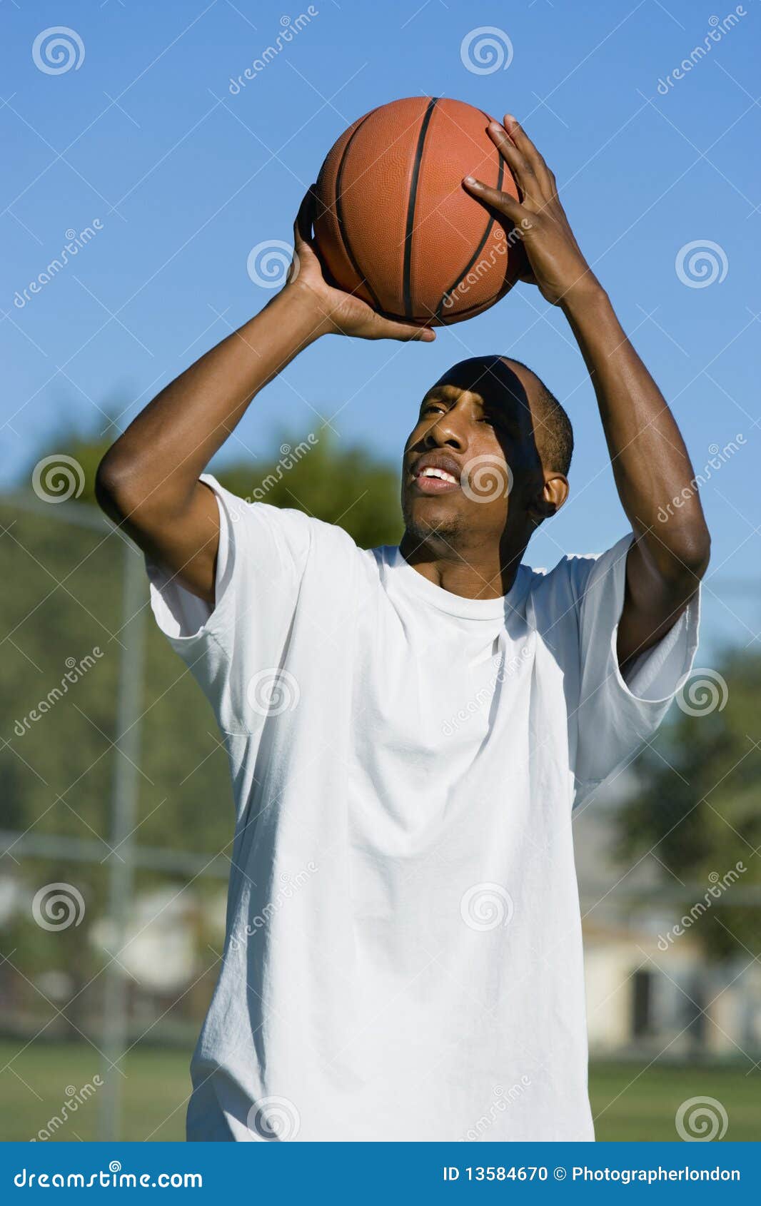Afrikaanse Amerikaanse Mens die basketbal poogt te ontspruiten