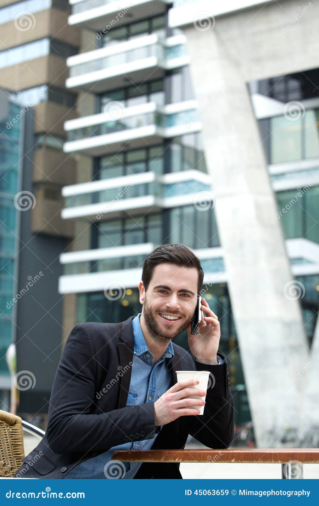 Portret van een jonge mens die en van koffie glimlachen genieten