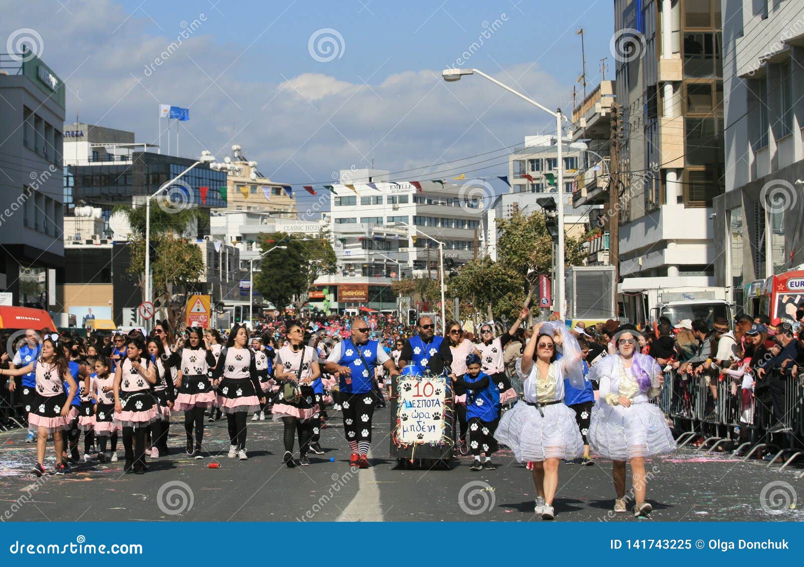 Mensen die in Carnaval-kostuums langs een straat lopen. Limassol, Cyprus, 10 Maart, 2019: Mannen, vrouwen en kinderen die in Carnaval-kostuums langs Aartsbisschop Makarios III Weg lopen tijdens Grote Carnaval-Parade van Jaarlijks Limassol Carnaval Festival Karnavali Lemesou