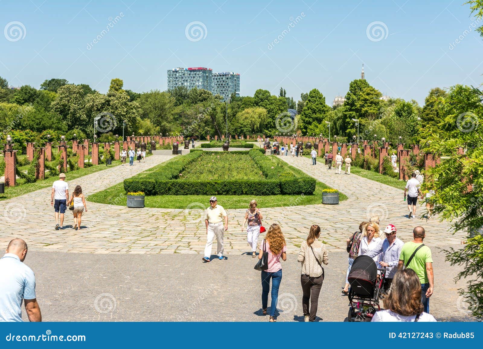 Mensen die een Gang in Herastrau-Park nemen. BOEKAREST, ROEMENIË - JUNI 29, 2014: Mensen die een Gang op de Zomerdag nemen in het Openbare Park van Herastrau Geopend in 1939 is het het grootste park van de stad en aan de noordelijke kant van Boekarest gevestigd