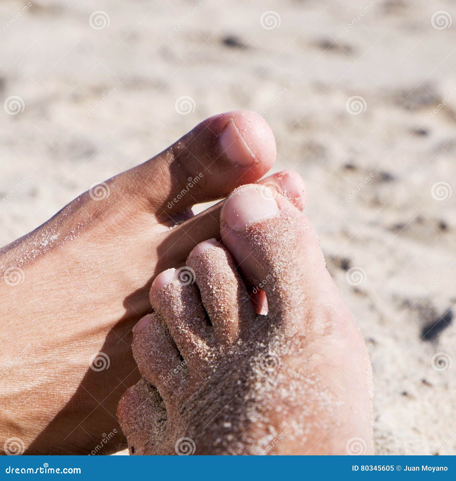 Close-up van de voeten van twee jonge mensen die footsie op het strand spelen