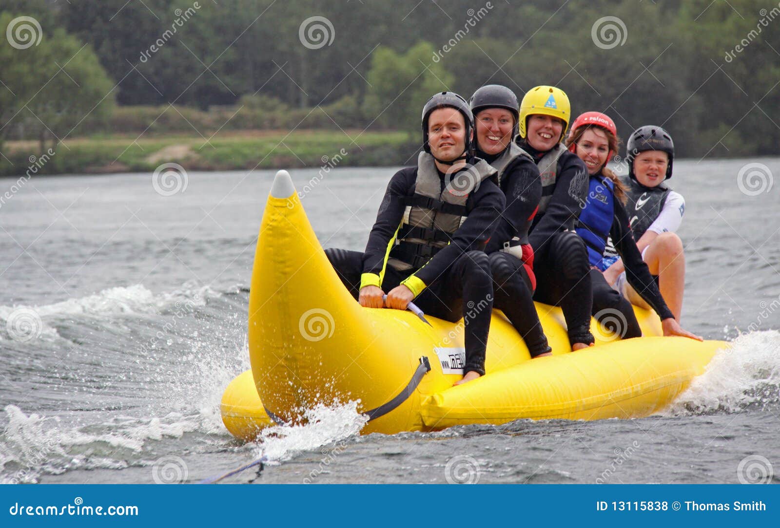 Mensen die op een banaanboot berijden. Mensen die en pret berijden hebben op een banaanboot op een water het skiån meer bij de Britse Gehandicapte Skiånde Vereniging BDWSA, het Meer van de Reiger, Wraysbury, het UK 1/8/09 van het Water