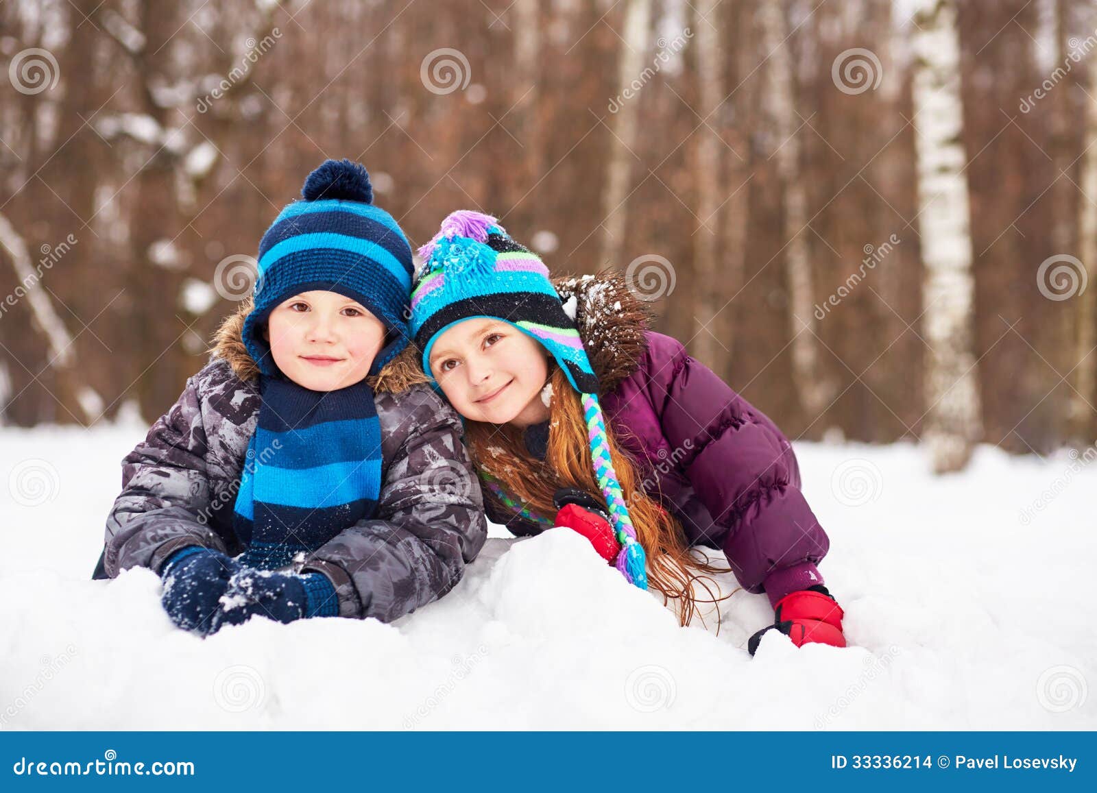 Mensonge de petite fille et de garçon tout près sur la congère en parc d'hiver