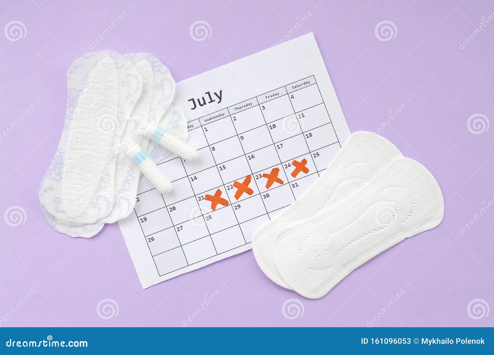 menstrual pads and tampons on menstruation period calendar flat lay on lilac background