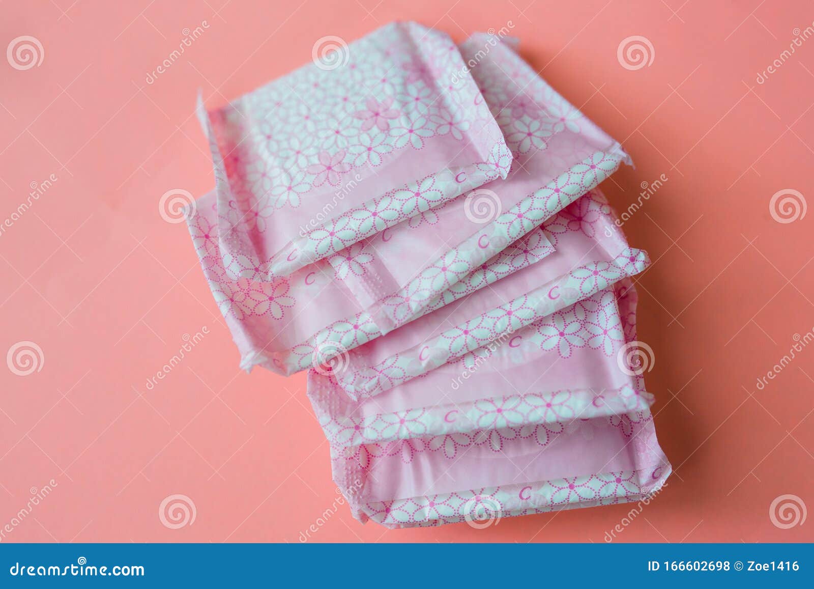 menstruation, wrapped pink period pads against pink background